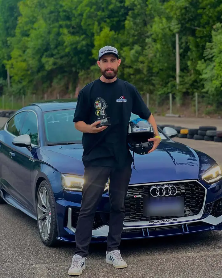 Jonatam com troféu ao lado do Audi A5 azul na pista