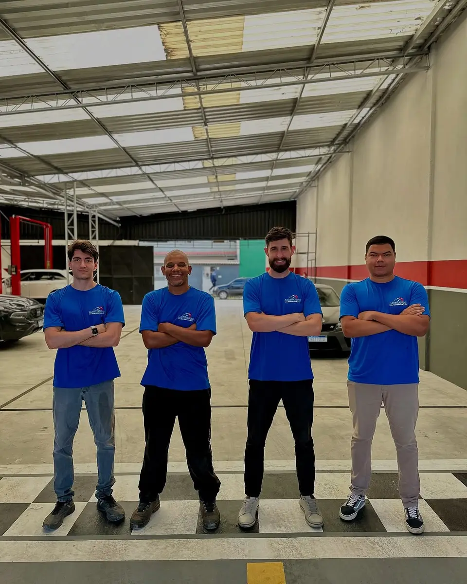 Equipe da Modesto Performance na oficina, de camiseta azul